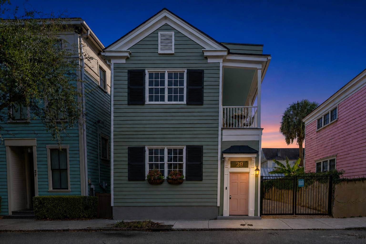 Breezy Palm at twilight, lantern glowing beside the pink door